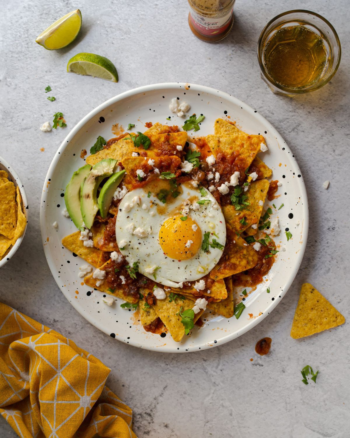 Τραγανά chips τορτίγιας (nachos), πικάντικη, ελαφρά καπνιστή σάλτσα, ένα τηγανητό αβγό, και μπόλικη αλμυρή φέτα. Και δε θα χρειαστεί ούτε κρεμμύδι να ψιλοκόψεις. Αλητεία;